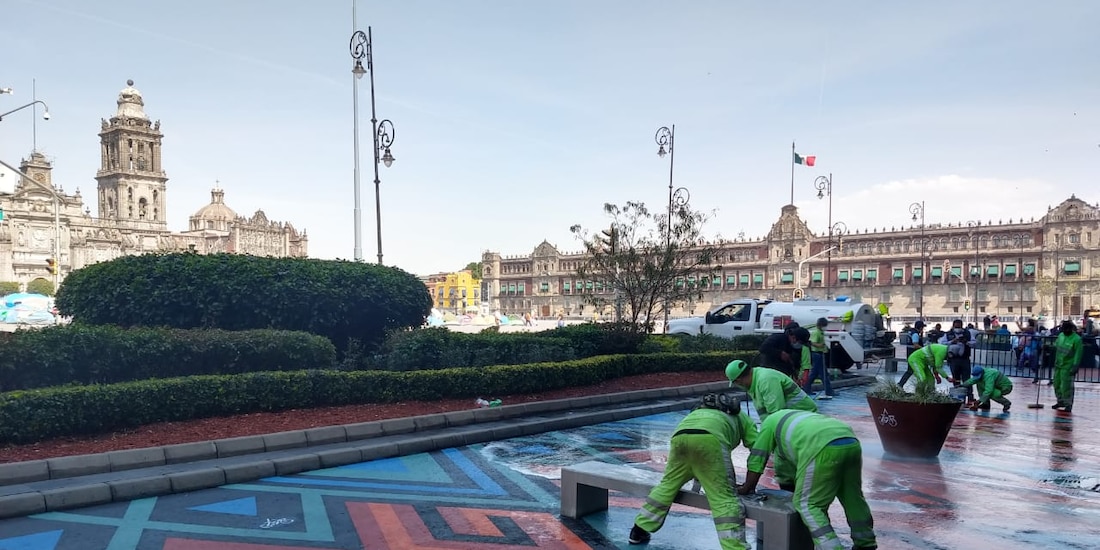 Personal de limpieza intenta remover las pintas sobre las coloridas representaciones de los textiles oaxaqueños