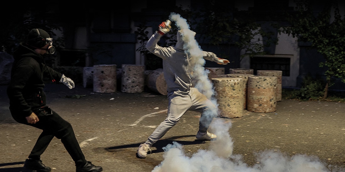 Un manifestante lanza gas lacrimógeno hacia la policía, en Tirana, Albania, ayer.