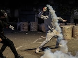 Un manifestante lanza gas lacrimógeno hacia la policía, en Tirana, Albania, ayer.