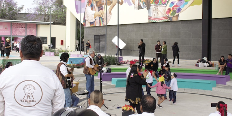 Una banda toca canciones para niños en el foro al aire libre.