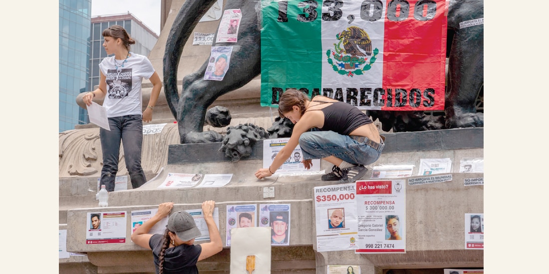 Mujeres colocan fichas de búsqueda durante la marcha en la CDMX.
