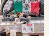 Mujeres colocan fichas de búsqueda durante la marcha en la CDMX.