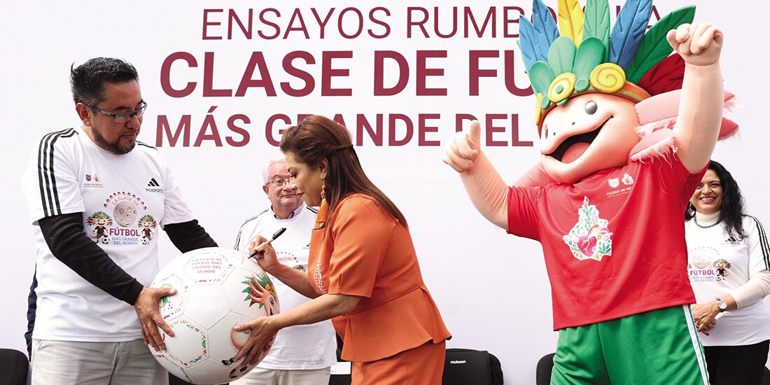 Clara Brugada firma el Gran Balón Mundialista, ayer, durante el primer ensayo de la clase masiva de futbol.