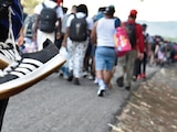 MIGRANTES CAMINAN en caravana el pasado 25 de marzo, en Huehuetán, Chiapas, rumbo al norte del país