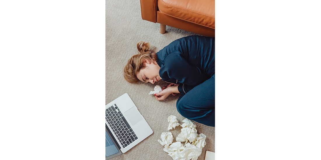 Una mujer se queda dormida enfrente de su computadora en foto de archivo.
