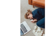 Una mujer se queda dormida enfrente de su computadora en foto de archivo.