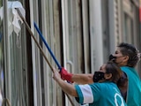 Un par de mujeres trabajan limpiando los cristales de un edificio en Paseo de la Reforma