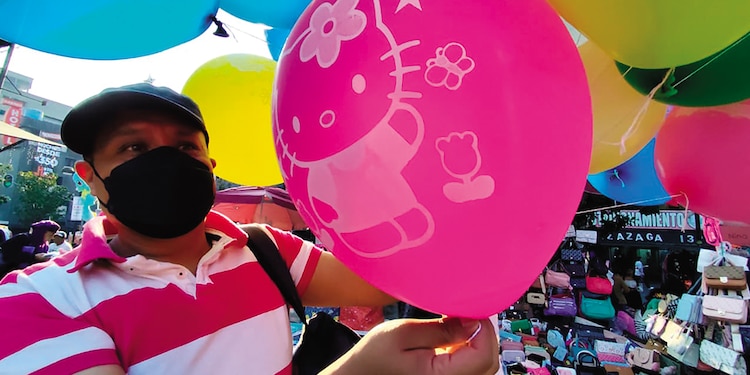 Un comerciante en Pino Suárez recorre la plaza para vender sus globos a los transeúntes.