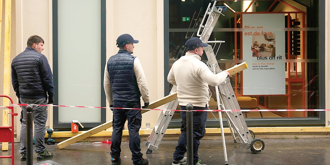 Trabajadores colocan barreras en comercios de París, ayer.