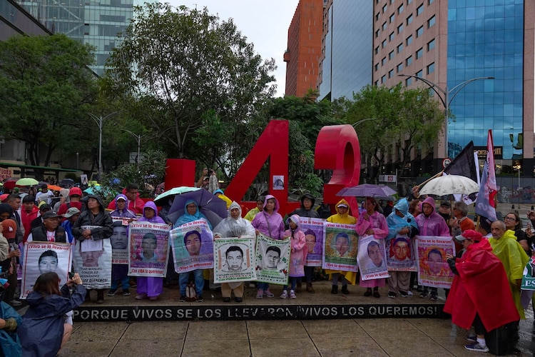 Familiares de los 43 estudiantes desaparecidos en Ayotzinapa posan frente al Antimonumento.