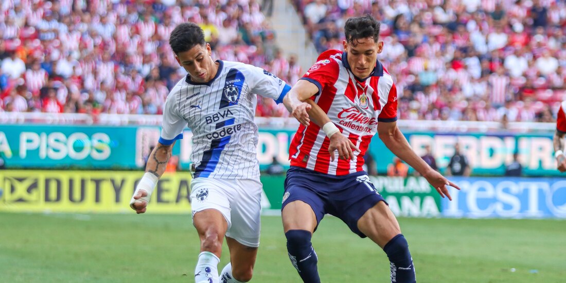 Maxi Meza y Jesús Orozco pelean por un balón en el cotejo entre Chivas y Monterrey.