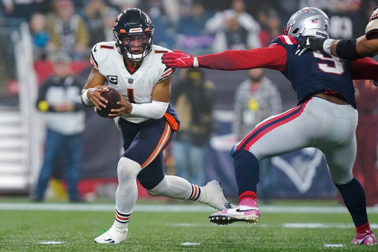 El quarterback Justin Fields (1) de los Chicago Bears supera al linebacker de los New England Patriots Matthew Judon (9)