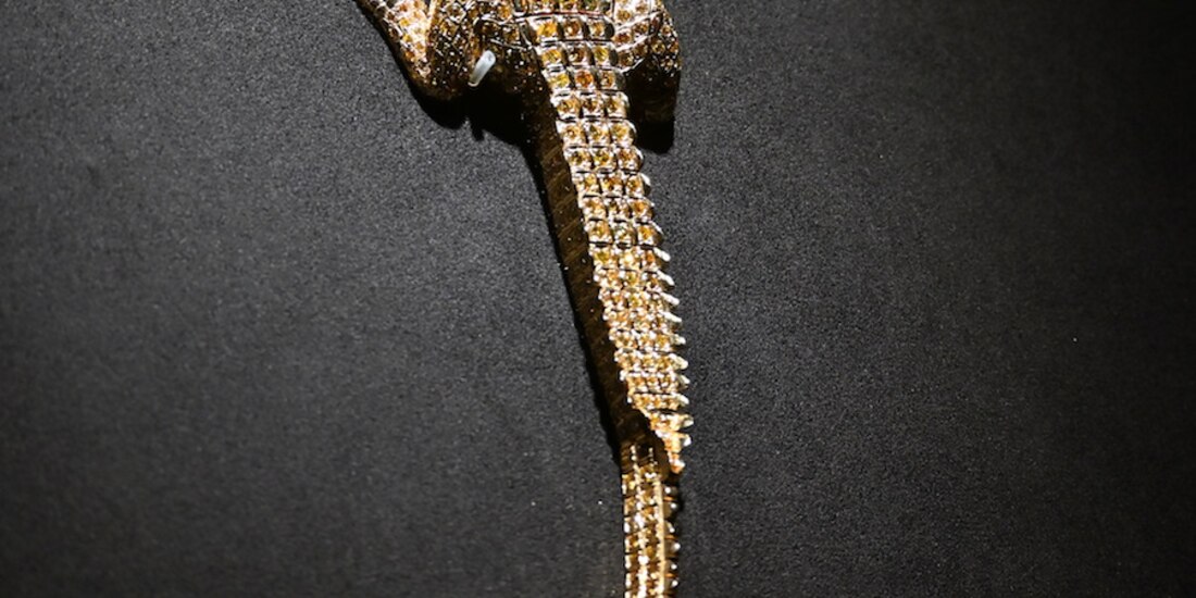 La joya tiene detalles en color verde.