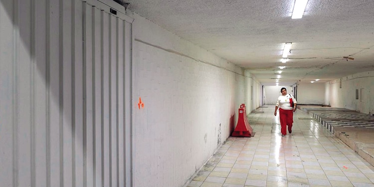Usuarios caminan por uno de los pasillos de un paso a desnivel vacío.