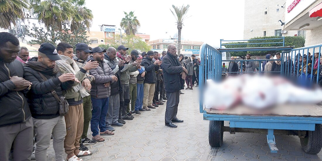 Palestinos rezan por sus muertos afuera de un hospital en la Franja de Gaza, ayer.