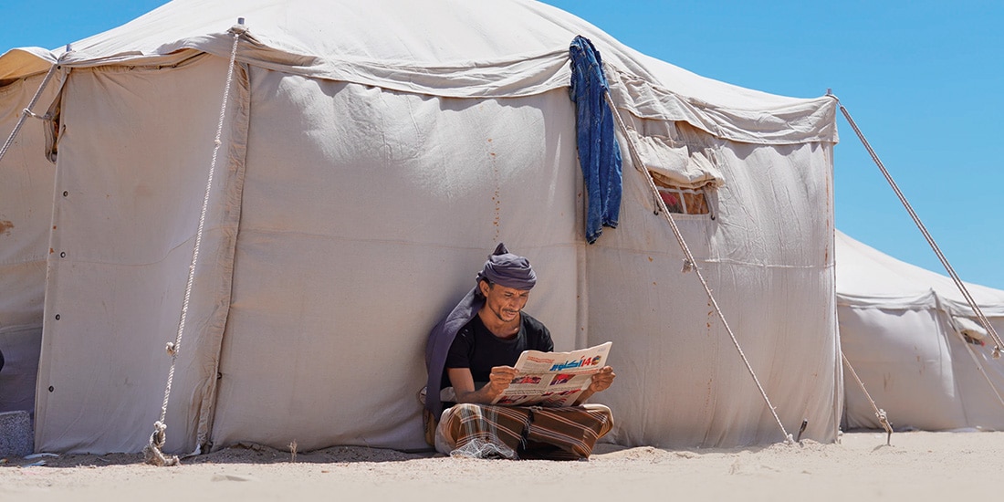 Un yemení desplazado lee un periódico en un campamento, en las afueras de Adén, Yemen, ayer.