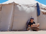 Un yemení desplazado lee un periódico en un campamento, en las afueras de Adén, Yemen, ayer.