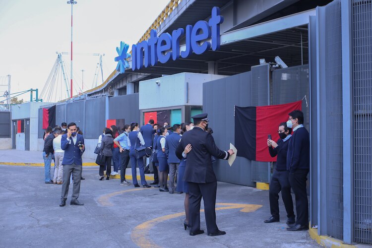 Trabajadores colocan banderas de huelga en edificio de Interjet, ayer.