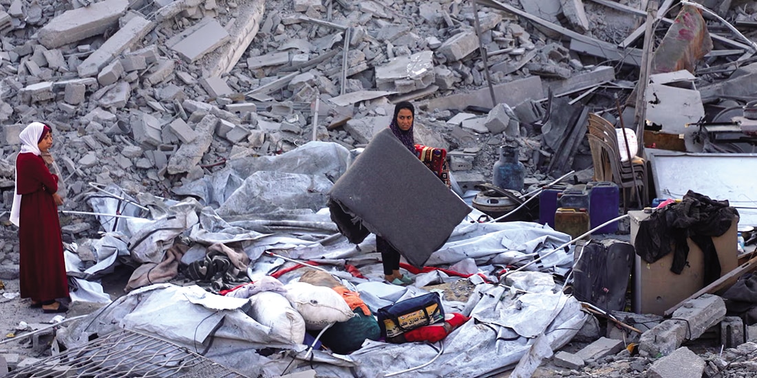 Palestinos inspeccionan el lugar donde Israel atacó una casa durante la noche en Nuseirat, en el centro de la Franja de Gaza, ayer.