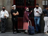 Personas con cubrebocas hacen fila antes de ingresar a un banco el 6 de julio de 2020, en el centro de la Ciudad de México.