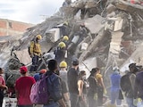 RESCATISTAS buscan víctimas atrapadas en un edificio, en Cali, ayer