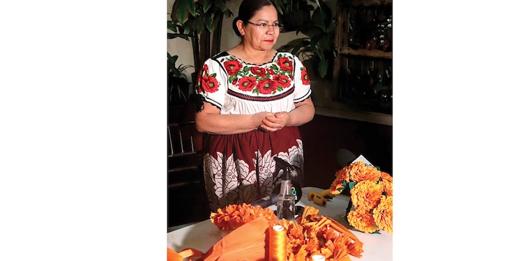 ARTESANA elabora flores con hojas de maíz.
