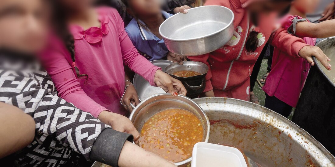 Palestinos reciben comida preparada por una cocina benéfica en Nuseirat, en la Franja de Gaza, el pasado 8 de abril.