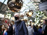 FILE PHOTO: A person wearing a protective face mask walks through Covent Garden, amid the coronavirus disease (COVID-19) outbreak, in London, Britain, December 4, 2021. REUTERS/Henry Nicholls/File Photo