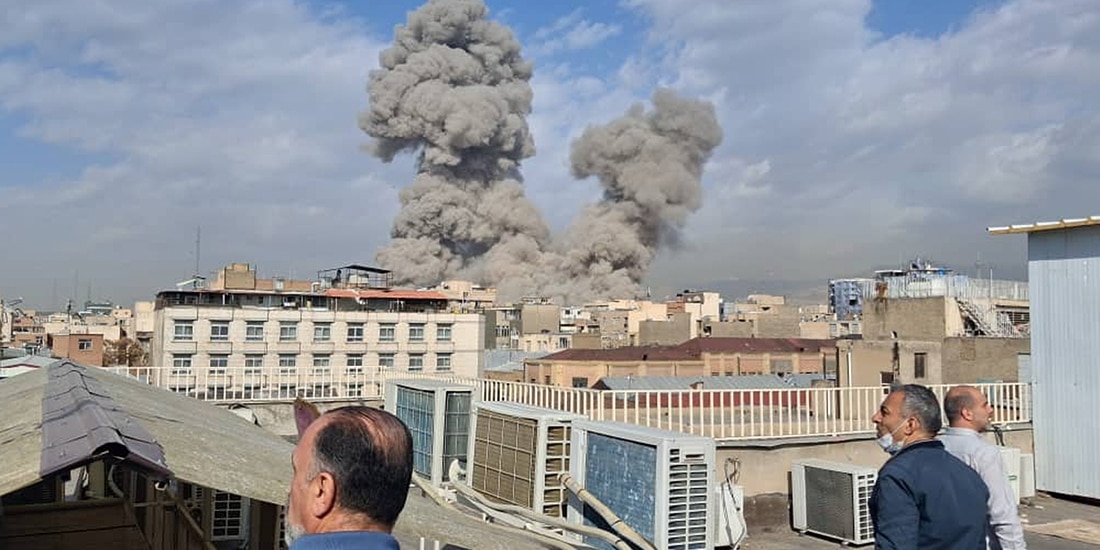Personas observan cómo el humo se eleva en el horizonte después de una explosión en Teherán, Irán, el sábado 28 de febrero de 2026.