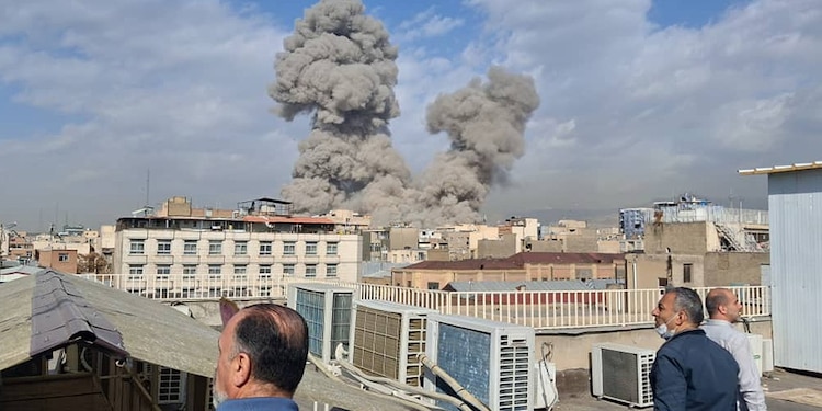 Personas observan cómo el humo se eleva en el horizonte después de una explosión en Teherán, Irán, el sábado 28 de febrero de 2026.