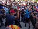 Personas se enfrentan a policías durante manifestaciones a favor y en contra del gobierno de Cuba