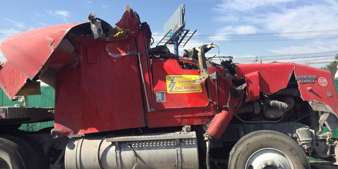Por el peso mal distribuido de la carga, el tráiler volcó y cayó sobre un auto.