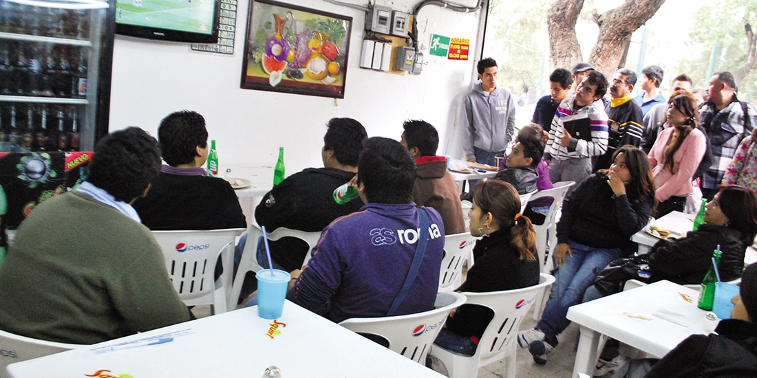 aficionados ven un partido de futbol dentro de un restaurante, en imagen de archivo.