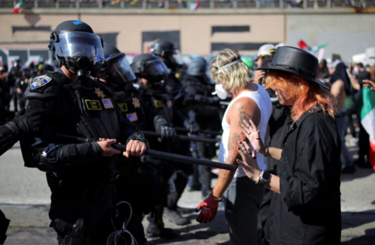Agentes de policía se enfrentan con migrantes, ayer.