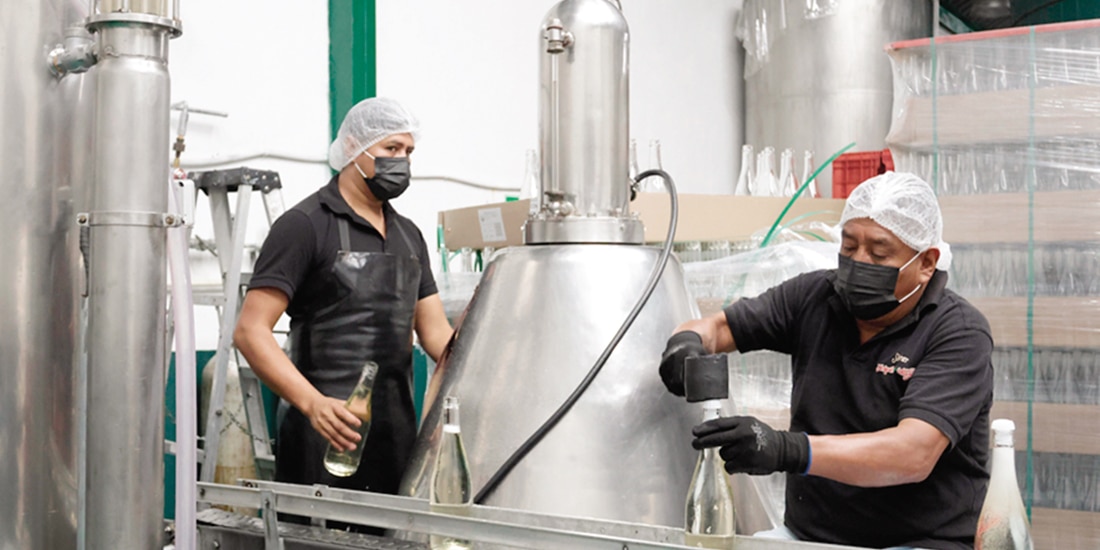 Dos personas trabajando en una fábrica de sidras, en Puebla, en diciembre.