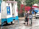 Dos hombres acuden a unos baños improvisados en una camioneta, ayer.