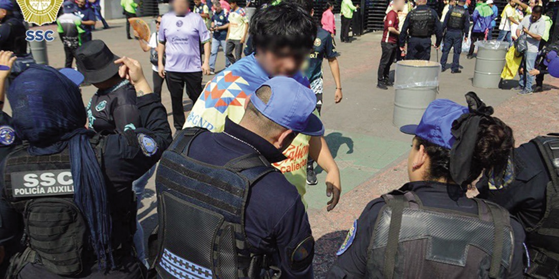 Policías revisan a aficionados del América, en el Estadio Banorte, en 2024.