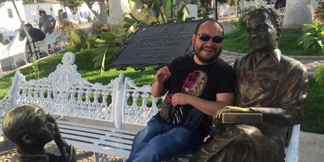 Hugo César Moreno en Comala, junto a la estatua de Rulfo.