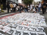 Integrantes de colectivos de búsqueda llevan a cabo una pega de fichas de personas desaparecidas, en Ciudad de México.