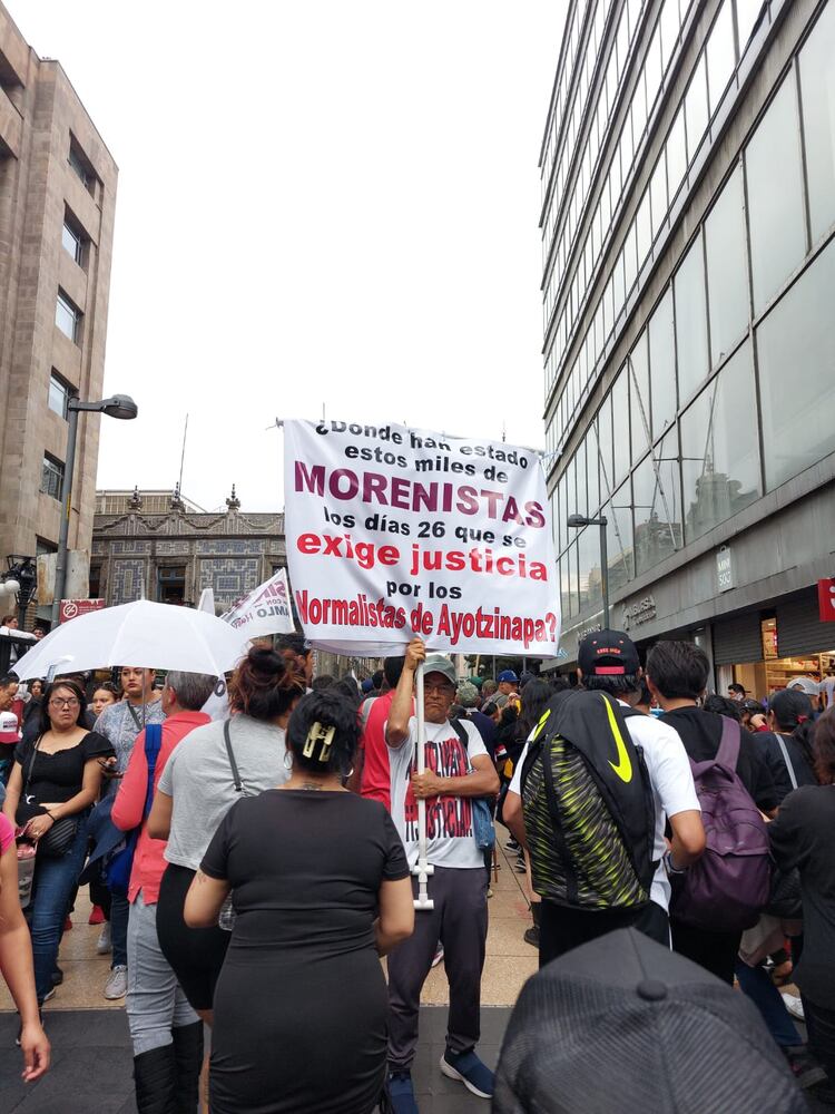 Un hombre lleva una pancarta donde exige justicia por el caso de los 43 desaparecidos de Ayotzinapa