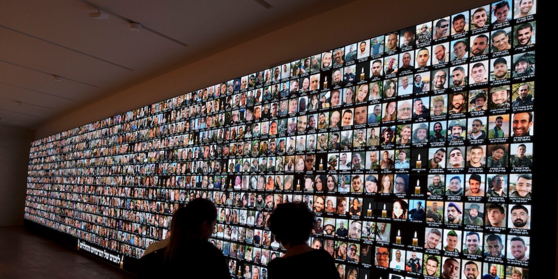 Israelíes ven los rostros de víctimas de Hamas, ayer.