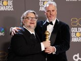 Guillermo del Toro, izq., y Mark Gustafson posan con el galardón.