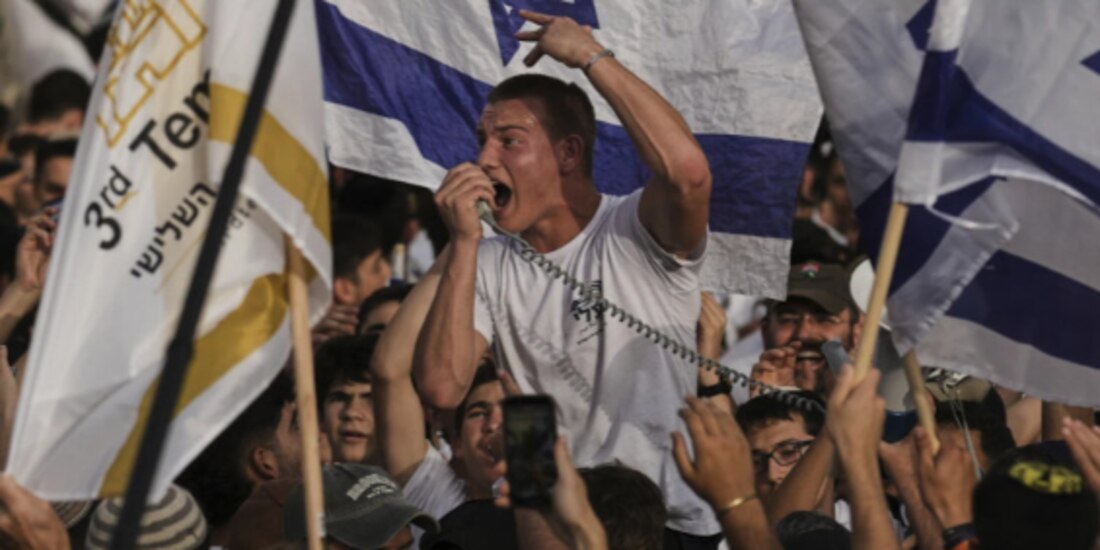 Israelíes ondean banderas nacionales durante la marcha en la Ciudad Vieja de Jerusalén, ayer, en conmemoración del Día de Jerusalén.