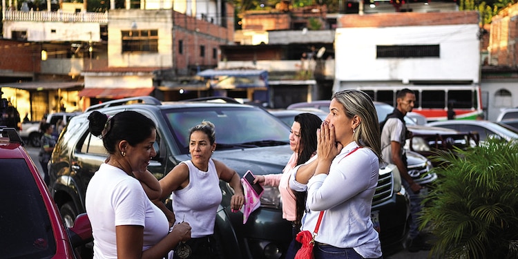 Mujeres se reúnen fuera de la cárcel de El Rodeo para esperar a sus familiares detenidos, en el estado de Miranda, Venezuela, ayer.