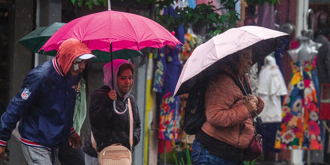 Personas abrigadas caminando en calles de Toluca, durante bajas temperaturas registradas, en julio.