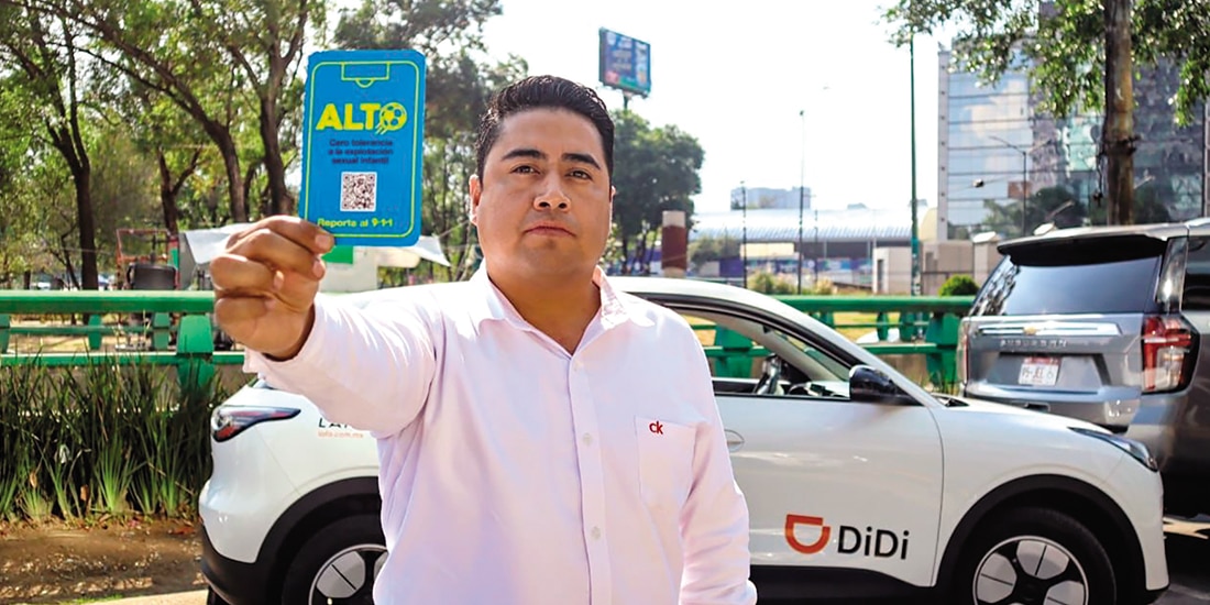 Un conductor de Didi muestra la Tarjeta Azul contra la trata, ayer.