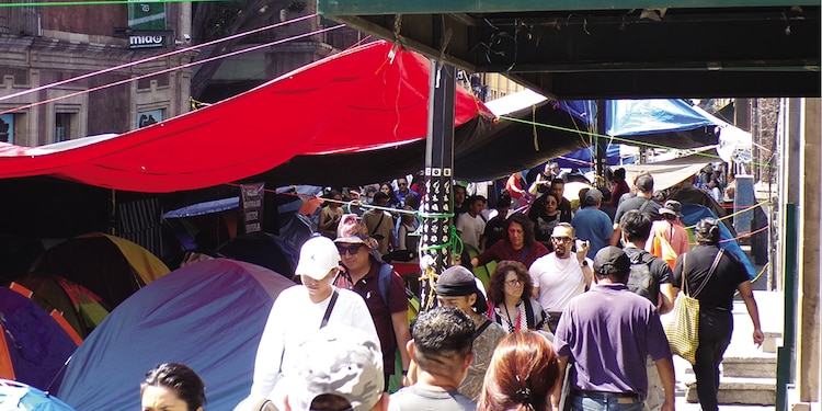 PEATONES ESQUIVAN casas de campaña de maestros en calle Bolívar, ayer.