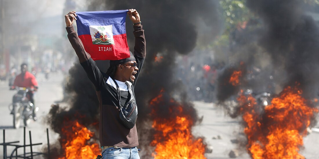 Una persona sostiene una bandera de Haití durante una protesta