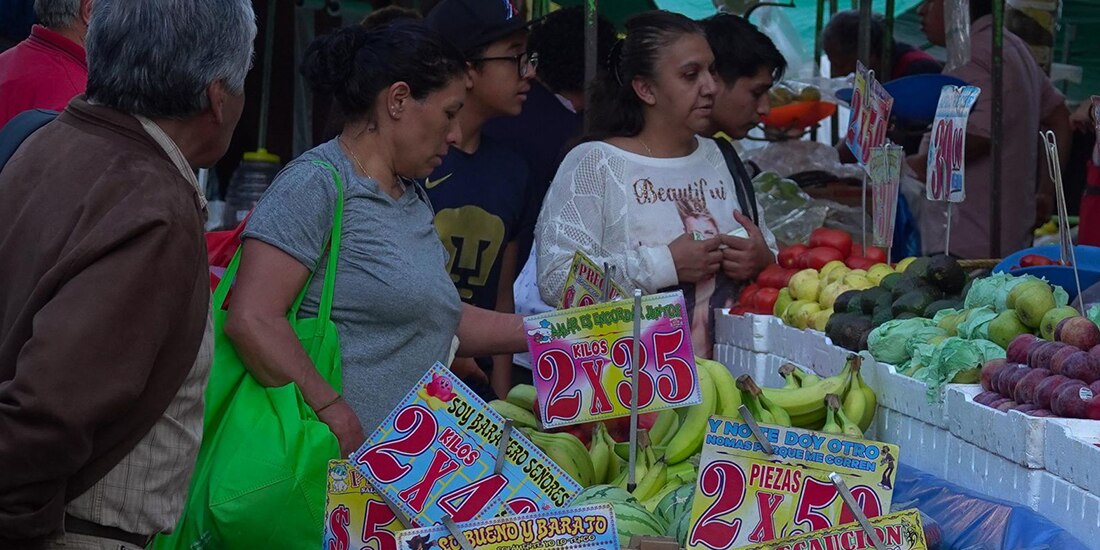 La imagen muestra a personas realizando compras de frutas