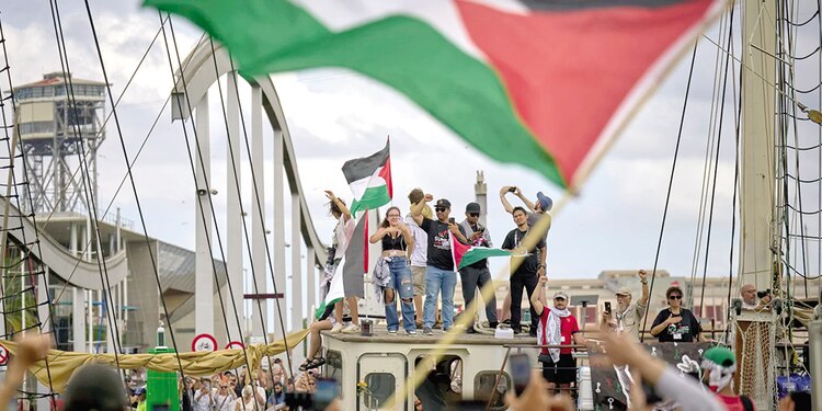 Activistas saludan desde un barco con destino a Gaza, ayer.